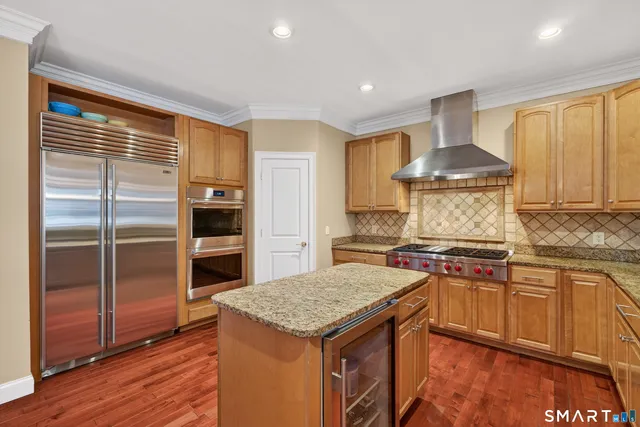 a kitchen with stainless steel appliances granite countertop hardwood floor sink stove and granite counter top
