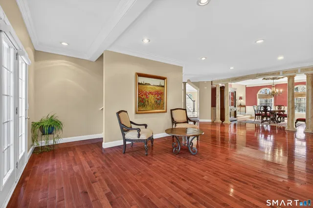a living room with furniture and kitchen view with wooden floor