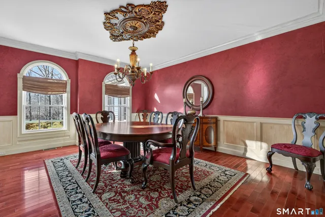 a dining room with furniture a chandelier and wooden floor