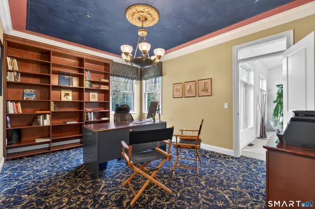 a living room with furniture a chandelier and a floor to ceiling window