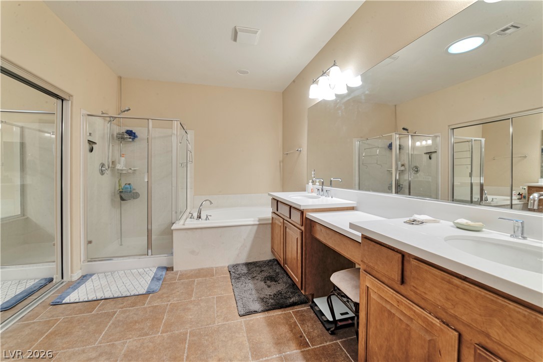 5915 Karnes Ranch Avenue Las Vegas, NV 89131 - Photo 14 of 28 Full bath with double vanity, two vanities, a shower stall, and a garden tub
