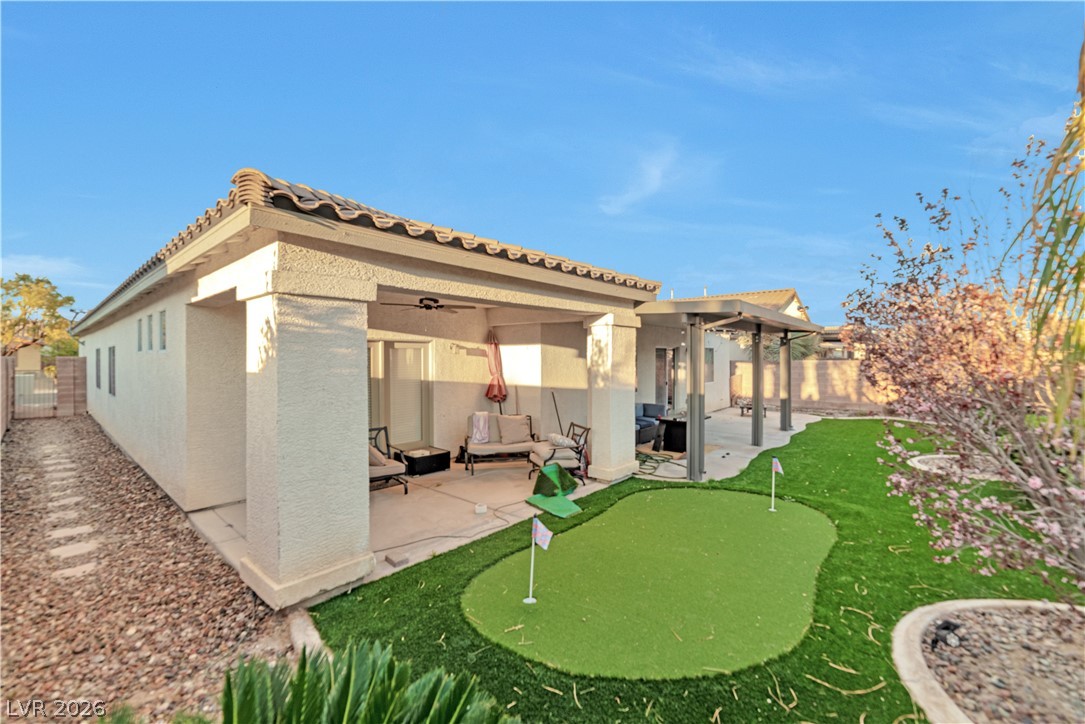 5915 Karnes Ranch Avenue Las Vegas, NV 89131 - Photo 15 of 28 Rear view of property featuring a putting area, stucco siding, and a patio