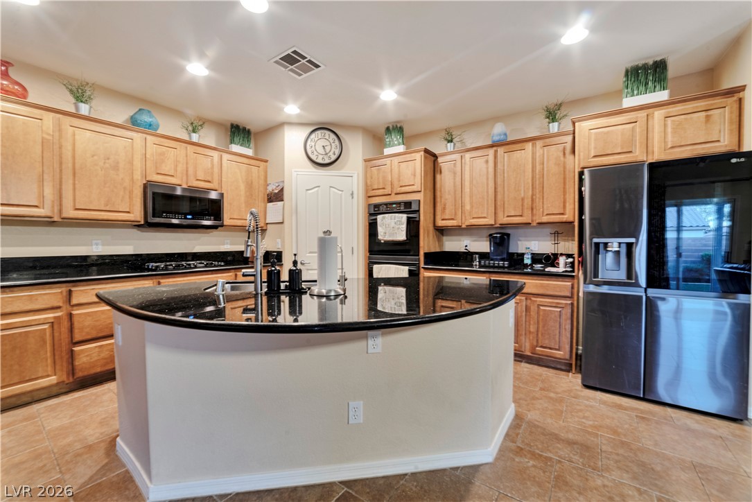 5915 Karnes Ranch Avenue Las Vegas, NV 89131 - Photo 19 of 28 Kitchen featuring black appliances, dark stone counters, a center island with sink, light wood finish cabinetry, and recessed lighting