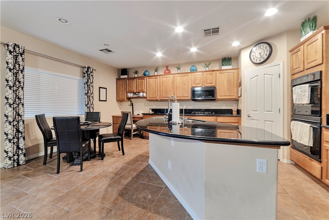 5915 Karnes Ranch Avenue Las Vegas, NV 89131 - Photo 20 of 28 Kitchen with an island with sink, dark stone counters, light wood finish cabinets, and recessed lighting