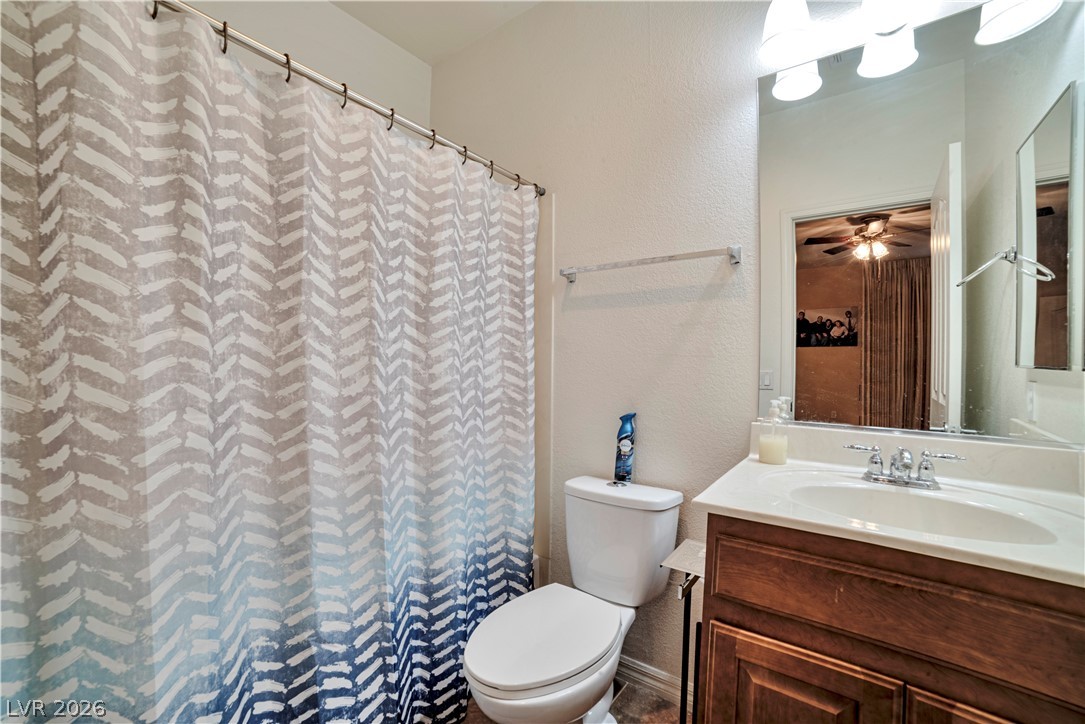 5915 Karnes Ranch Avenue Las Vegas, NV 89131 - Photo 24 of 28 Full bath with a textured wall, vanity, and a shower with curtain