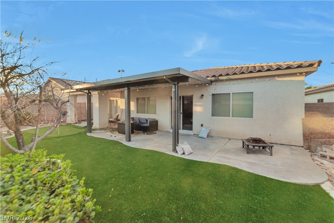 5915 Karnes Ranch Avenue Las Vegas, NV 89131 - Photo 5 of 28 Back of property with a patio, stucco siding, and an outdoor living space with a fire pit