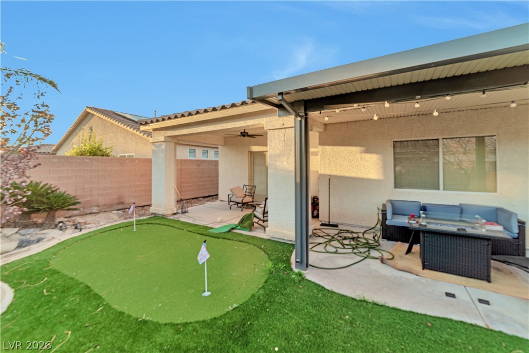5915 Karnes Ranch Avenue Las Vegas, NV 89131 - Photo 10 of 28 Back of property with a patio, a putting area, ceiling fan, stucco siding, and a fenced backyard