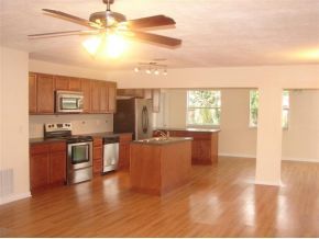 3197 Northeast Eastman Palm Bay, FL 32905 - Photo 2 of 11 a kitchen with stainless steel appliances kitchen island granite countertop a stove a sink and a refrigerator