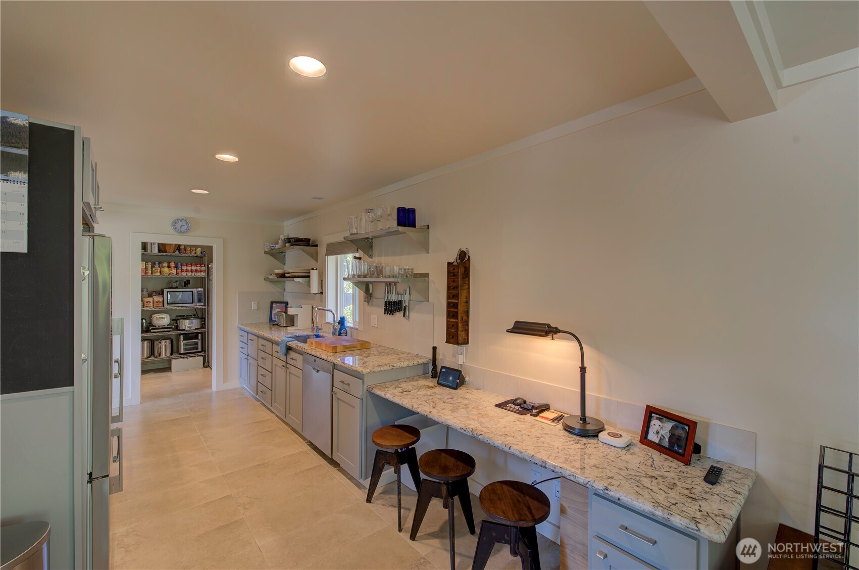 1115 34 Street Seaview, WA 98644 - Photo 14 of 31 a room with stainless steel appliances kitchen island a table chairs in it and a window
