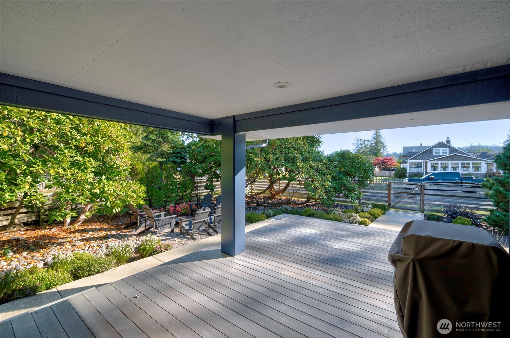 1115 34 Street Seaview, WA 98644 - Photo 2 of 31 a porch with a table and chairs next to a yard