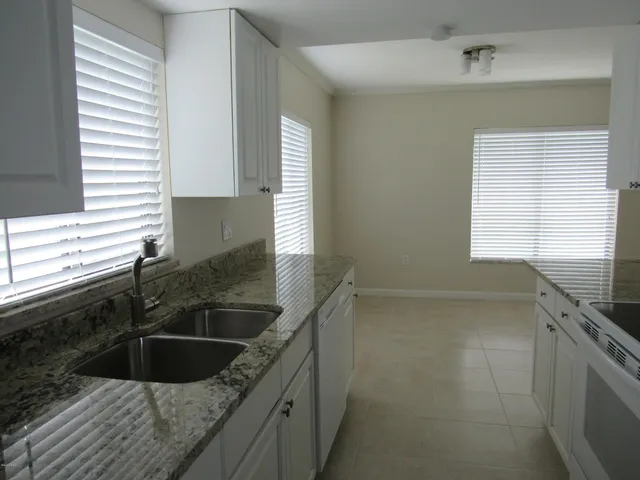 a kitchen with granite countertop a sink and a window