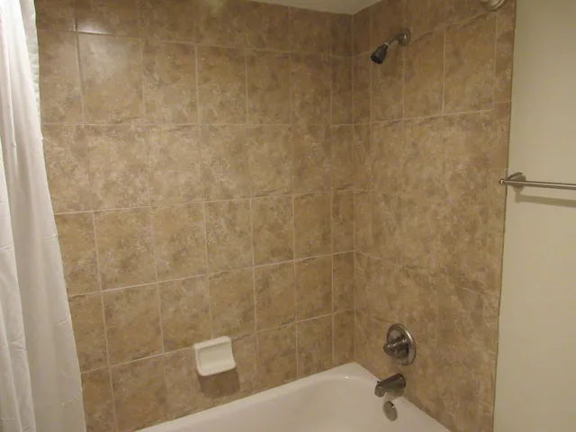 an empty room with a fan & a window