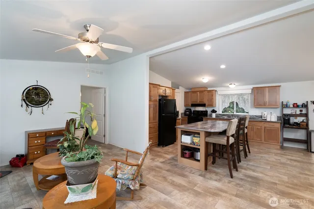 a kitchen with stainless steel appliances a refrigerator a stove a sink a dining table and chairs