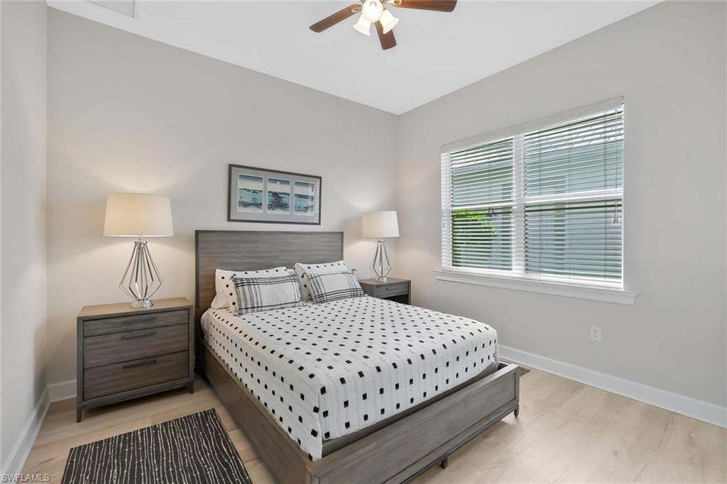 5167 Andros Drive Naples, FL 34113 - Photo 16 of 32 a bedroom with a large bed and a chandelier