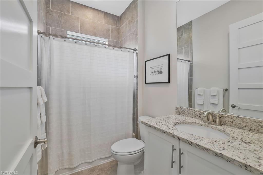 5167 Andros Drive Naples, FL 34113 - Photo 17 of 32 a bathroom with a granite countertop sink toilet and shower