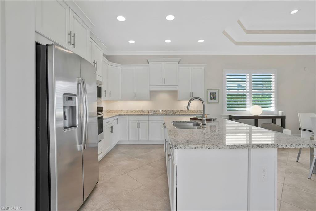 5167 Andros Drive Naples, FL 34113 - Photo 8 of 32 a kitchen with stainless steel appliances granite countertop a sink stove and refrigerator