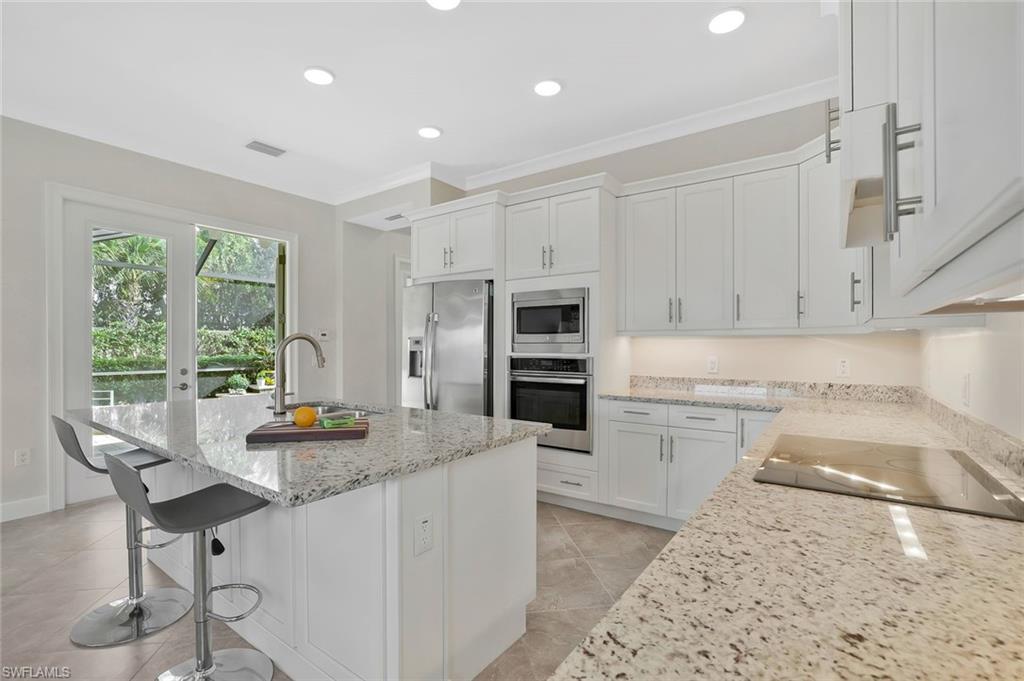 5167 Andros Drive Naples, FL 34113 - Photo 10 of 32 a kitchen with refrigerator cabinets and a counter top space