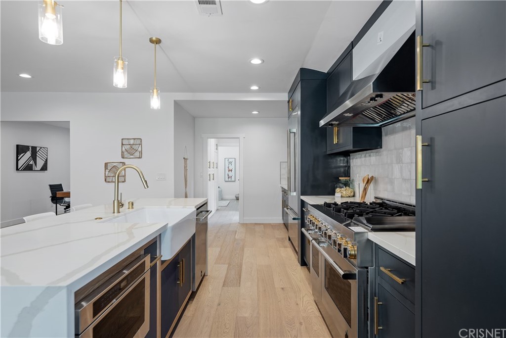 13151 Morrison Street Sherman Oaks, CA 91423 - Photo 6 of 26 a kitchen with stainless steel appliances a sink stove and cabinets