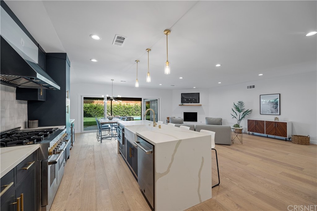 13151 Morrison Street Sherman Oaks, CA 91423 - Photo 7 of 26 a kitchen with stainless steel appliances kitchen island a stove a sink a refrigerator and a dining table with wooden floor