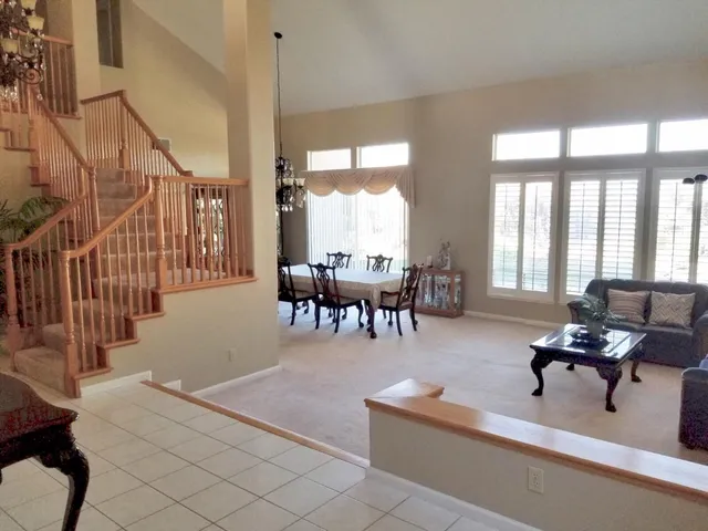 a living room with furniture and floor to ceiling windows