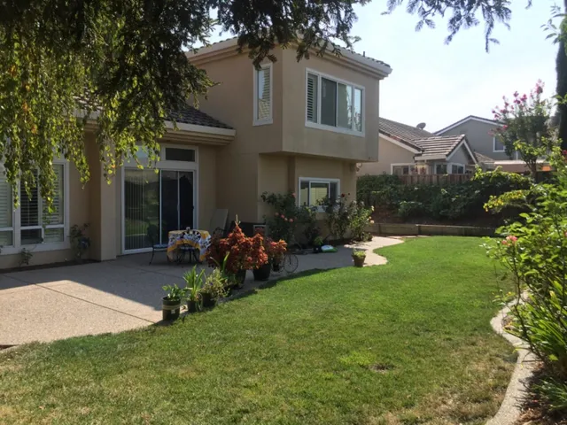 a view of a house with backyard sitting area and garden