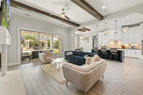 a large kitchen with a stove a sink dishwasher a dining table and chairs with wooden floor