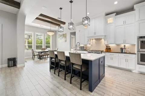 a kitchen with kitchen island granite countertop a sink a center island stainless steel appliances and cabinets