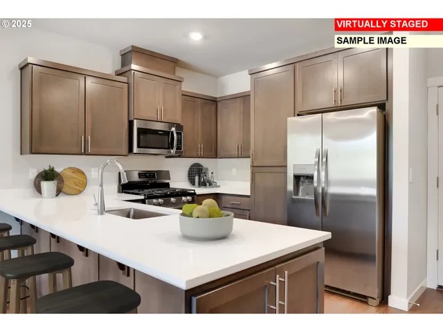 a kitchen with a sink a refrigerator and chairs