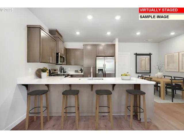 a kitchen with cabinets a sink dishwasher a island and chairs in it