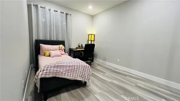 a bedroom with a bed and wooden floor