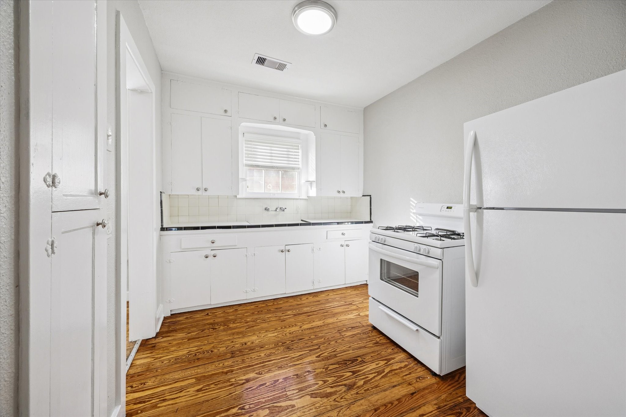 1812 West Alabama Street, Unit 4 Houston, TX 77098 - Photo 4 of 10 a kitchen with a stove cabinets and a refrigerator