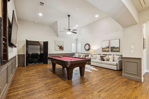 a living room with furniture a flat screen tv and kitchen view