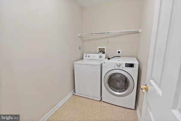 a kitchen with stainless steel appliances granite countertop a refrigerator a stove a sink and a white cabinets