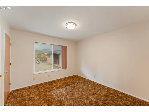 view of an empty room with wooden floor and a window