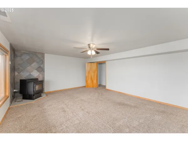 a view of a livingroom with a ceiling fan and window