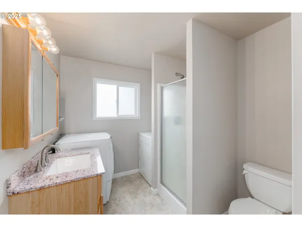 a bathroom with a granite countertop sink a toilet and a mirror