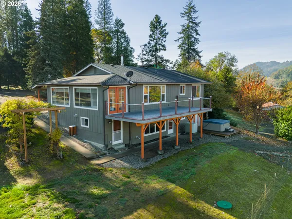 a view of a house with a wooden deck and a yard