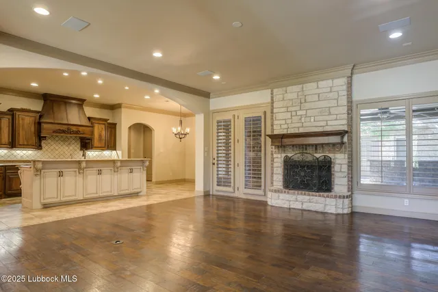 a view of empty room with wooden floor and windows