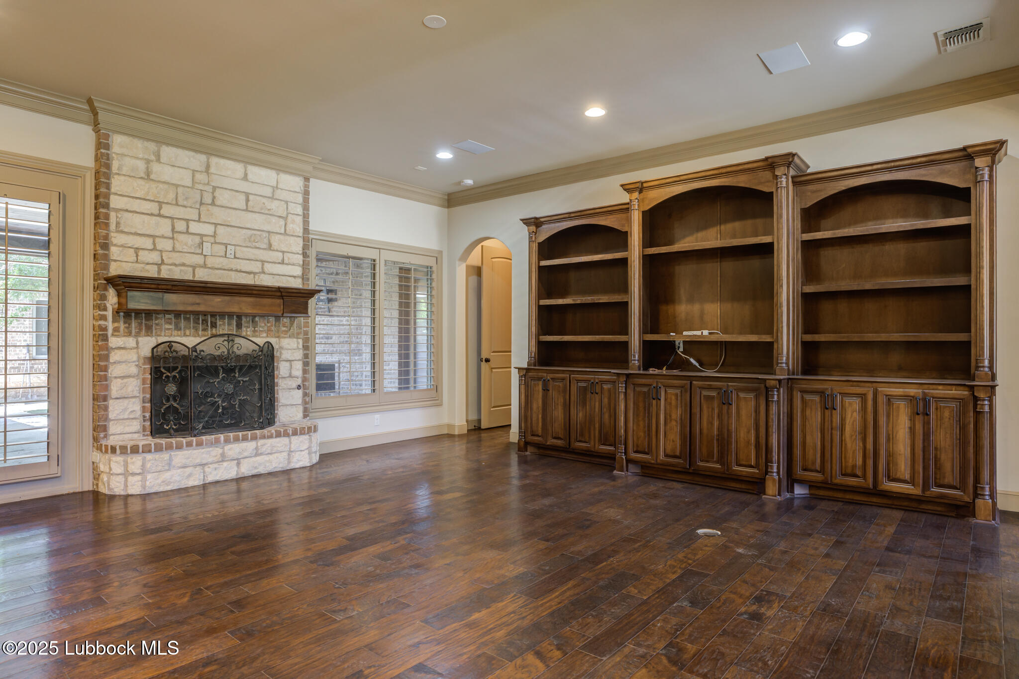 6103 89th Street Lubbock, TX 79424 - Photo 18 of 73 a view of an empty room with a fireplace and a window