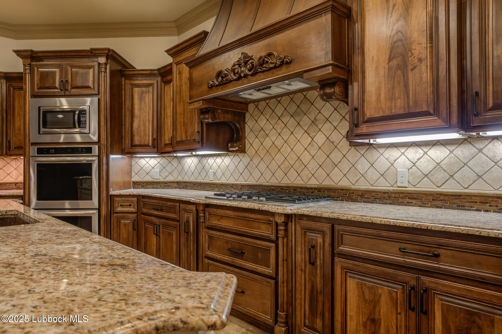 6103 89th Street Lubbock, TX 79424 - Photo 30 of 73 a kitchen with stainless steel appliances granite countertop a stove microwave and cabinets