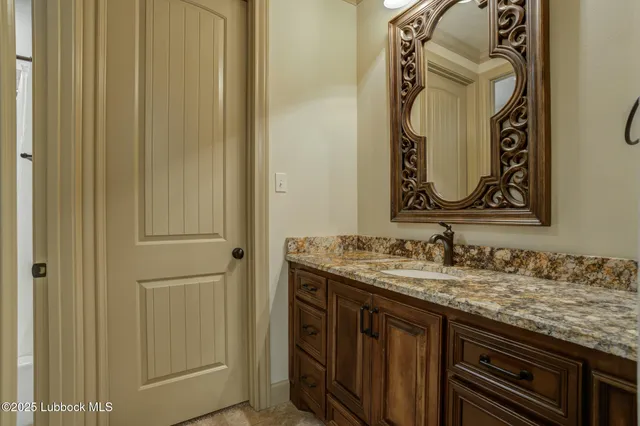 a bathroom with a granite countertop sink and a mirror