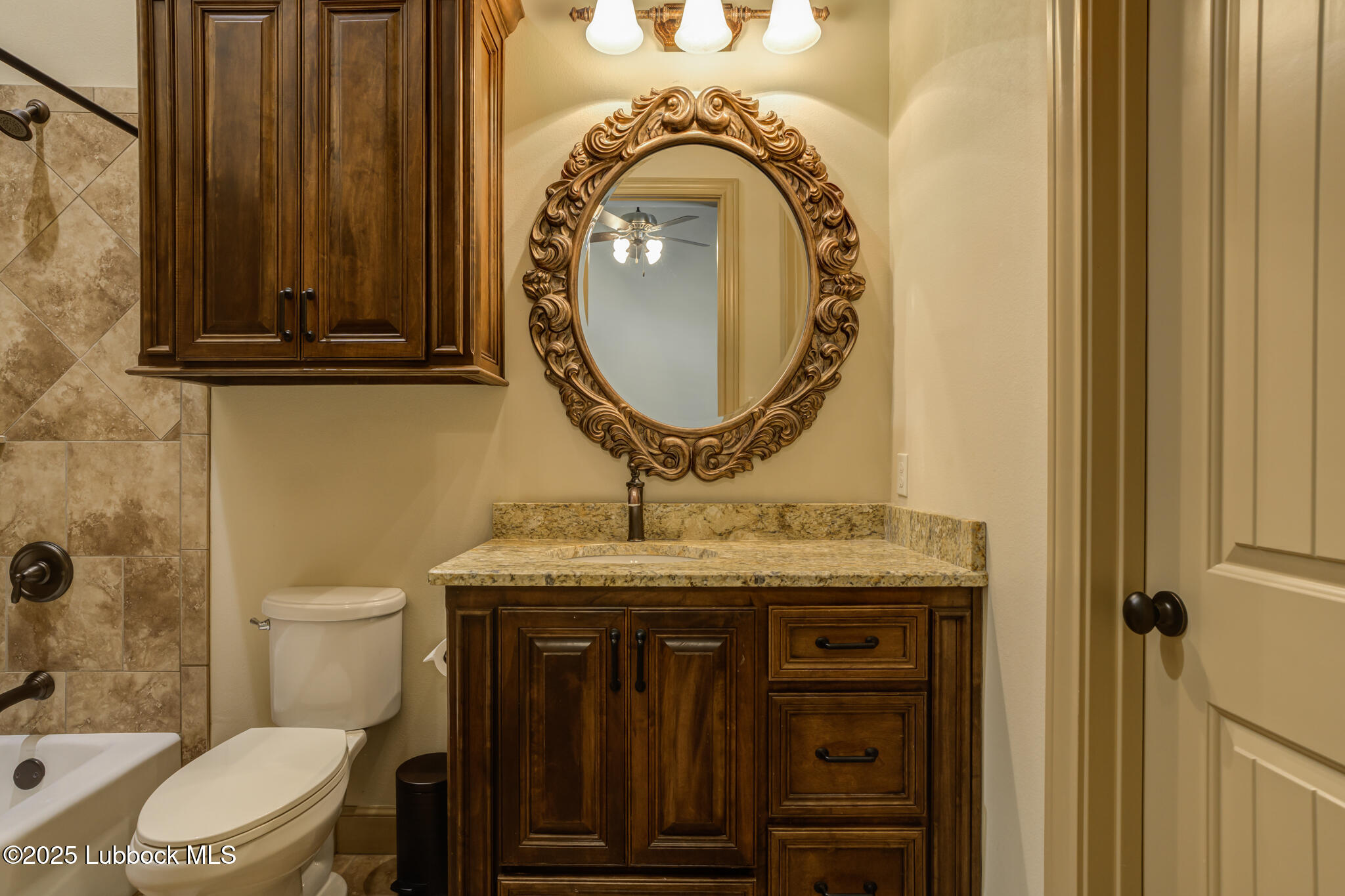 6103 89th Street Lubbock, TX 79424 - Photo 53 of 73 a bathroom with a granite countertop toilet and a sink