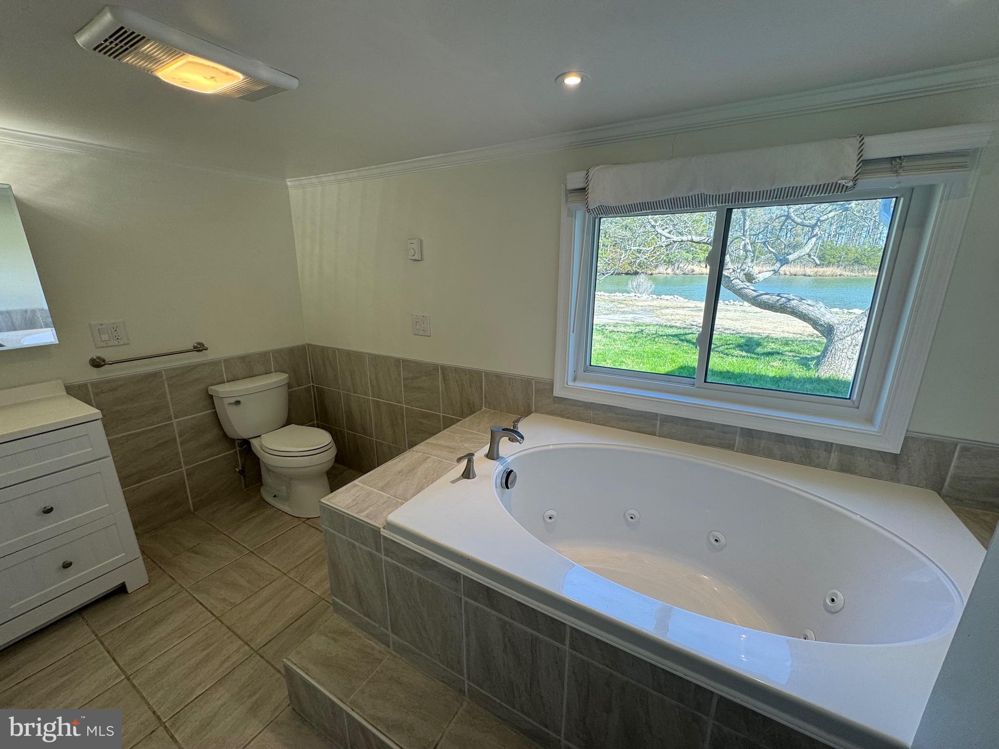 5511 Cassons Neck Road Cambridge, MD 21613 - Photo 18 of 20 a bathroom with a bathtub and a window