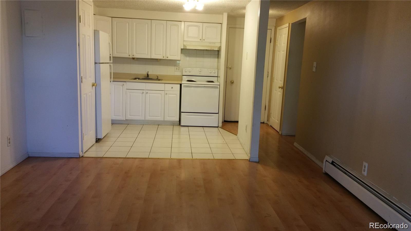 1304 South Parker Road, Unit 240 Denver, CO 80231 - Photo 5 of 19 a room with a stove and a refrigerator