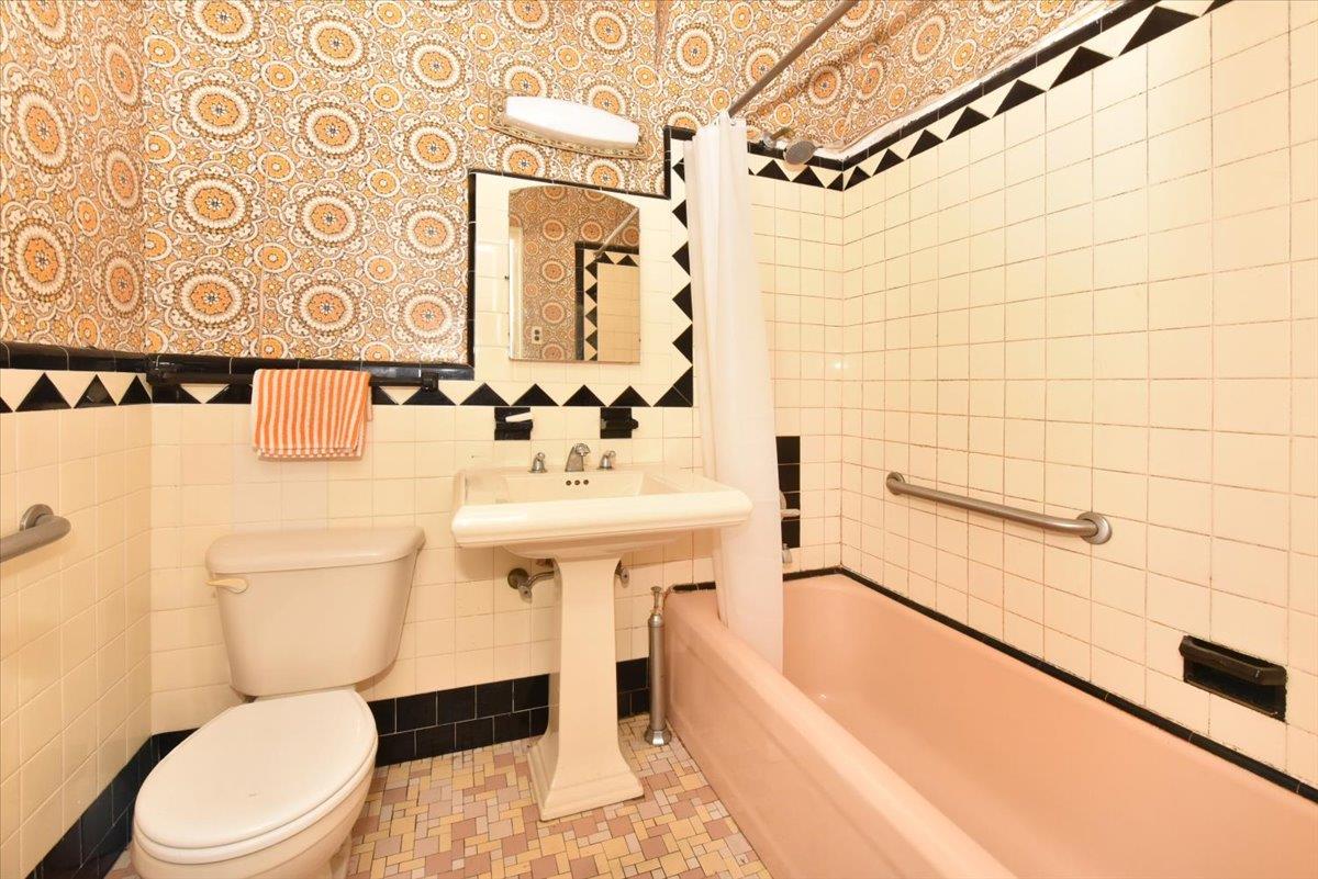 85-76 66th Road Queens, NY 11374 - Photo 11 of 20 Bathroom with tile walls and shower / bathtub combination with curtain