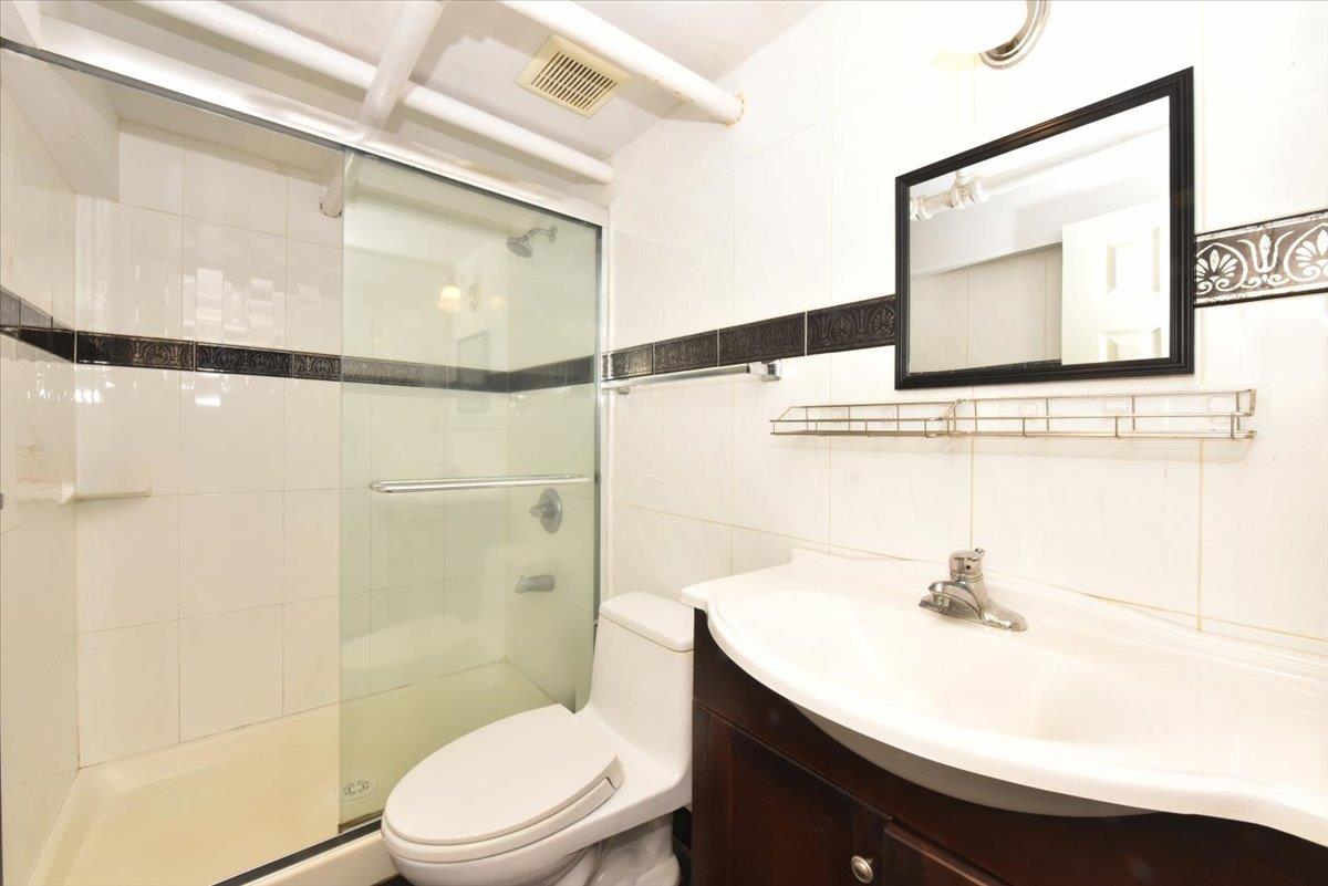 85-76 66th Road Queens, NY 11374 - Photo 15 of 20 Bathroom with a shower stall, tile walls, vanity, and tasteful backsplash