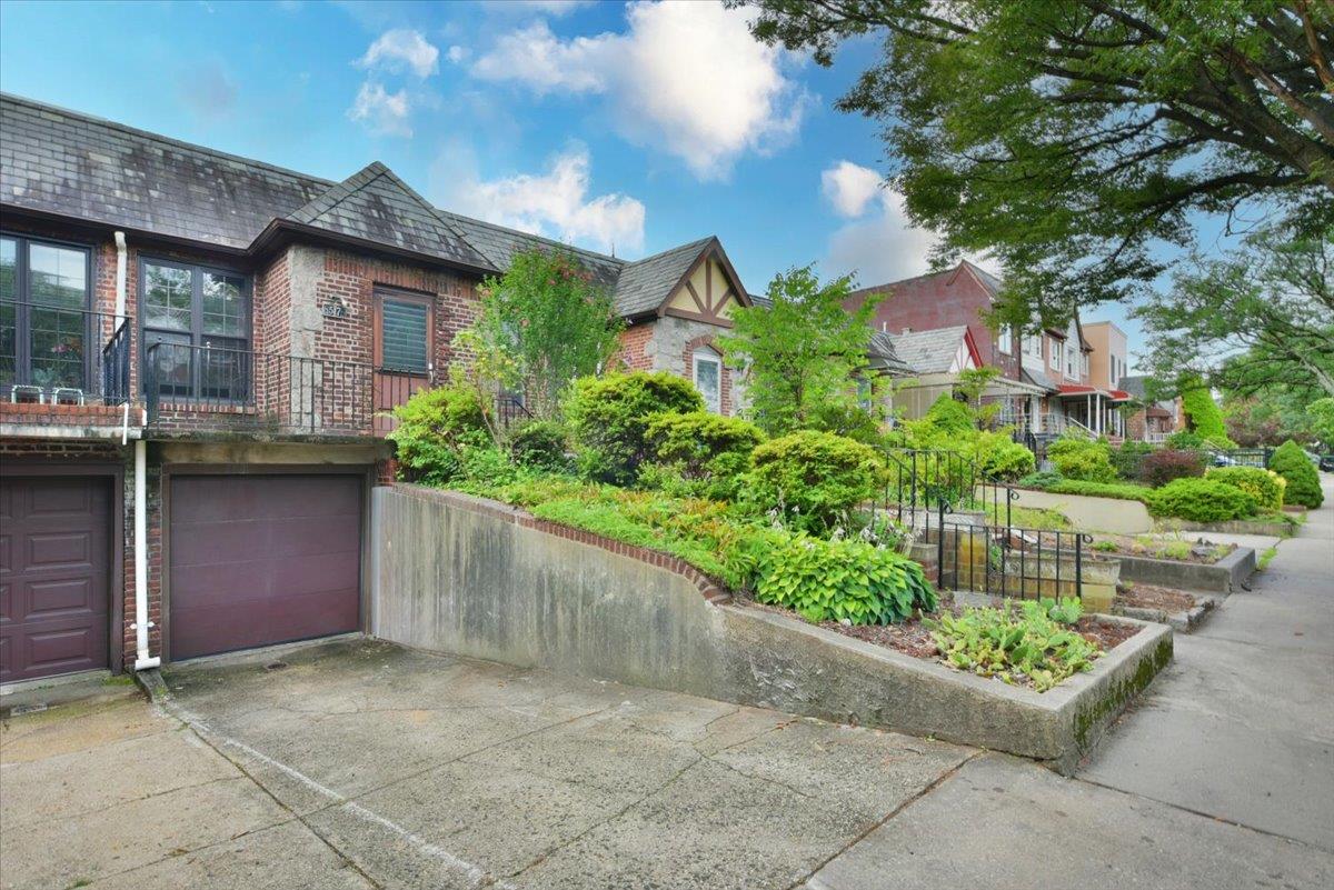 85-76 66th Road Queens, NY 11374 - Photo 2 of 20 View of front facade featuring brick siding, driveway, a high end roof, and a garage