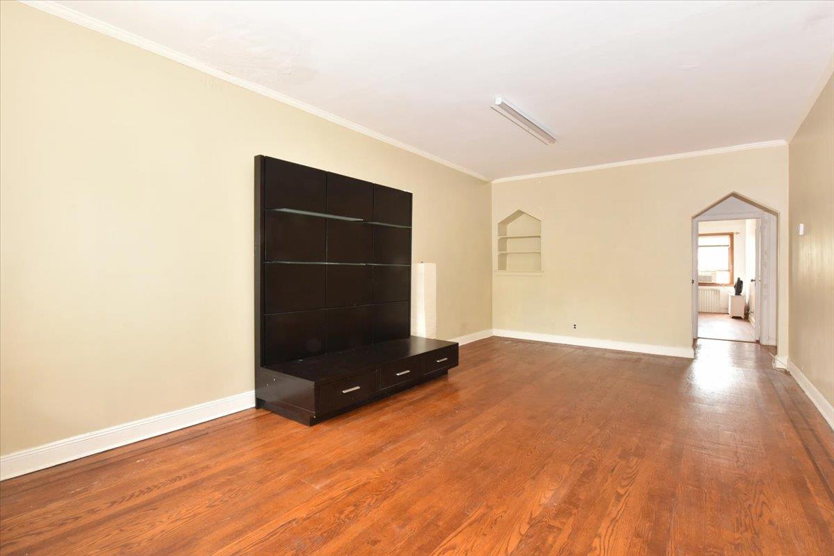 85-76 66th Road Queens, NY 11374 - Photo 6 of 20 Unfurnished living room featuring ornamental molding, dark wood finished floors, and arched walkways