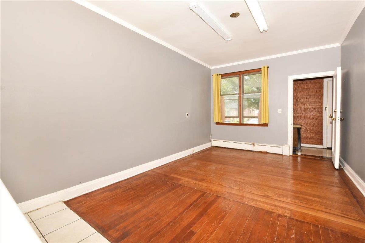 85-76 66th Road Queens, NY 11374 - Photo 7 of 20 Spare room with a baseboard radiator, ornamental molding, and hardwood / wood-style flooring