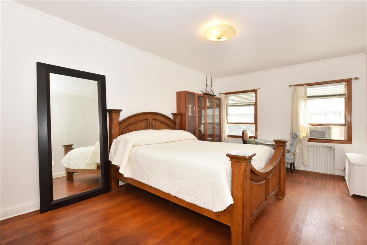 85-76 66th Road Queens, NY 11374 - Photo 9 of 20 Bedroom featuring wood finished floors, radiator heating unit, and crown molding